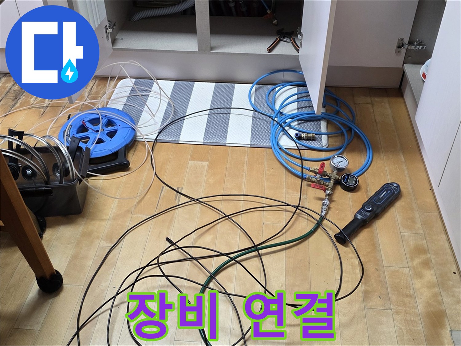 양주 누수 공사 - 싱크대 하부 압력 검사를 위해 압력 측정 장비를 꼼꼼하게 연결하고 있습니다.