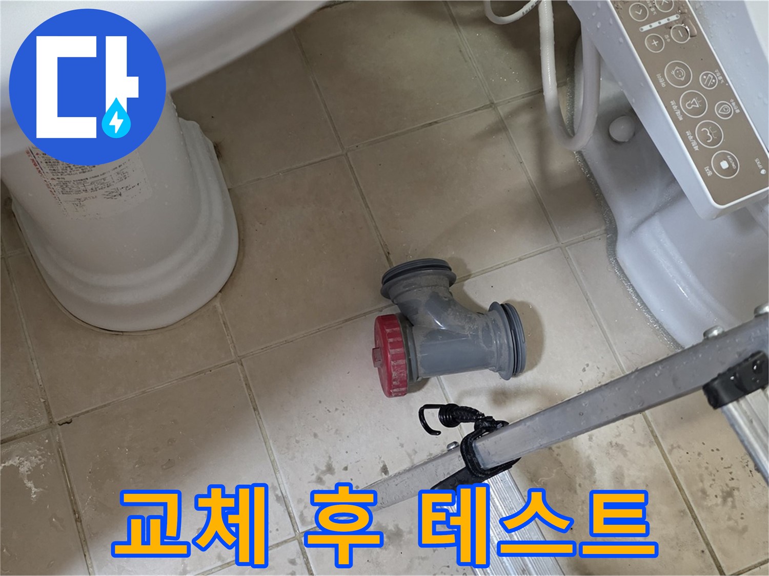 화장실 타일 바닥 위에 놓인 배관 자재와 작업 도구의 모습