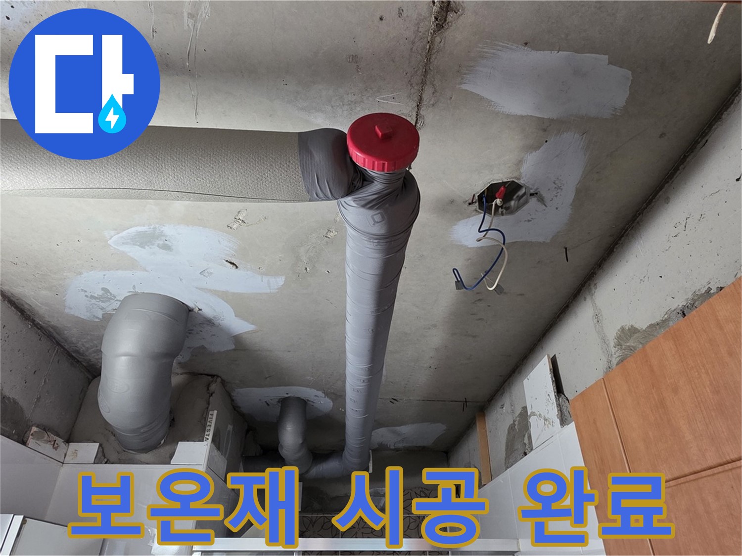 천장 내부 PVC 배관의 붉은색 캡과 연결된 엘보 부속을 클로즈업한 사진입니다.