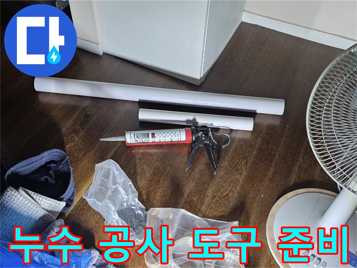 누수 공사를 위한 도구 준비 - 실리콘 건과 다양한 배관 자재들이 준비되어 있습니다.