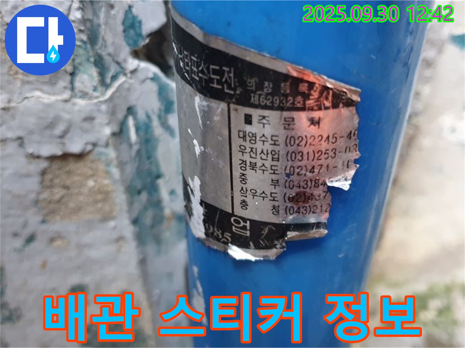 수도 배관에 부착된 오래된 스티커 - 시공 업체 정보와 함께 다양한 연락처가 적혀 있습니다.