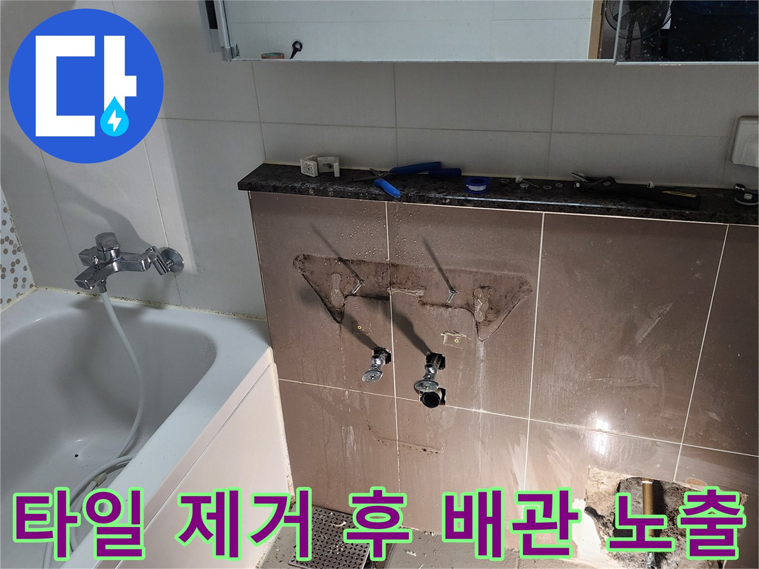 세면대 하부 벽면 타일을 깨서 드러낸 배관과 밸브 부위