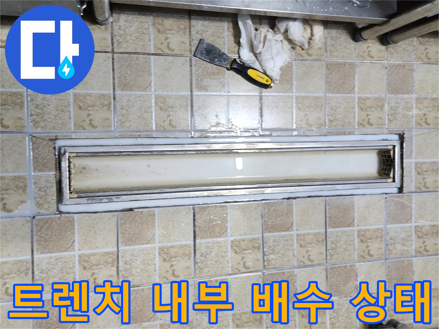 트렌치 내부의 물 고임과 주변 타일의 노후된 모습입니다.