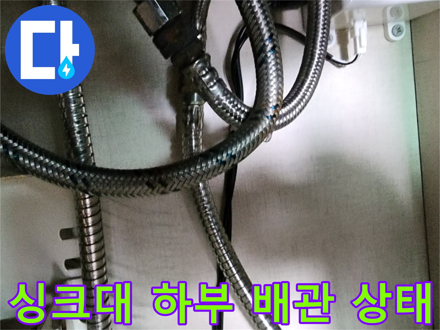 포천 송우리 싱크대 하부의 얽혀 있는 은색 스테인리스 편조 호스 모습