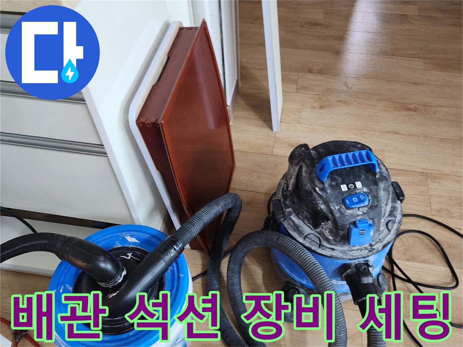 주방 싱크대 하부 배관 청소를 위해 준비된 강력한 석션 장비와 보조 통