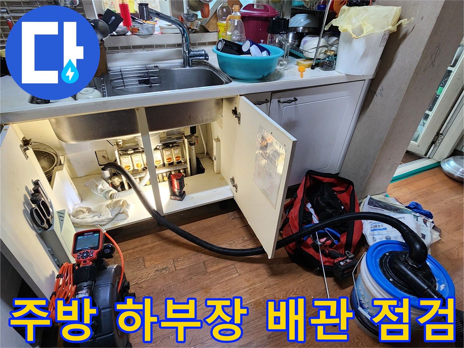 싱크대 아래쪽 배관과 전문 진단 장비가 배치된 작업 환경