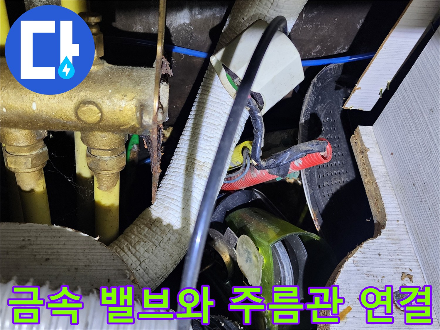 싱크대 하단 금속 배관 부품과 흰색 호스의 연결 지점 상세 사진입니다.