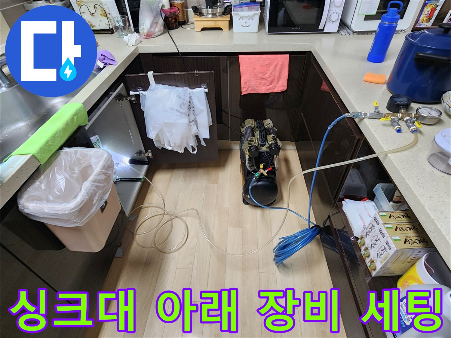 주방 싱크대 하부장 공간에 설치된 누수 탐지용 공압 테스트 장비