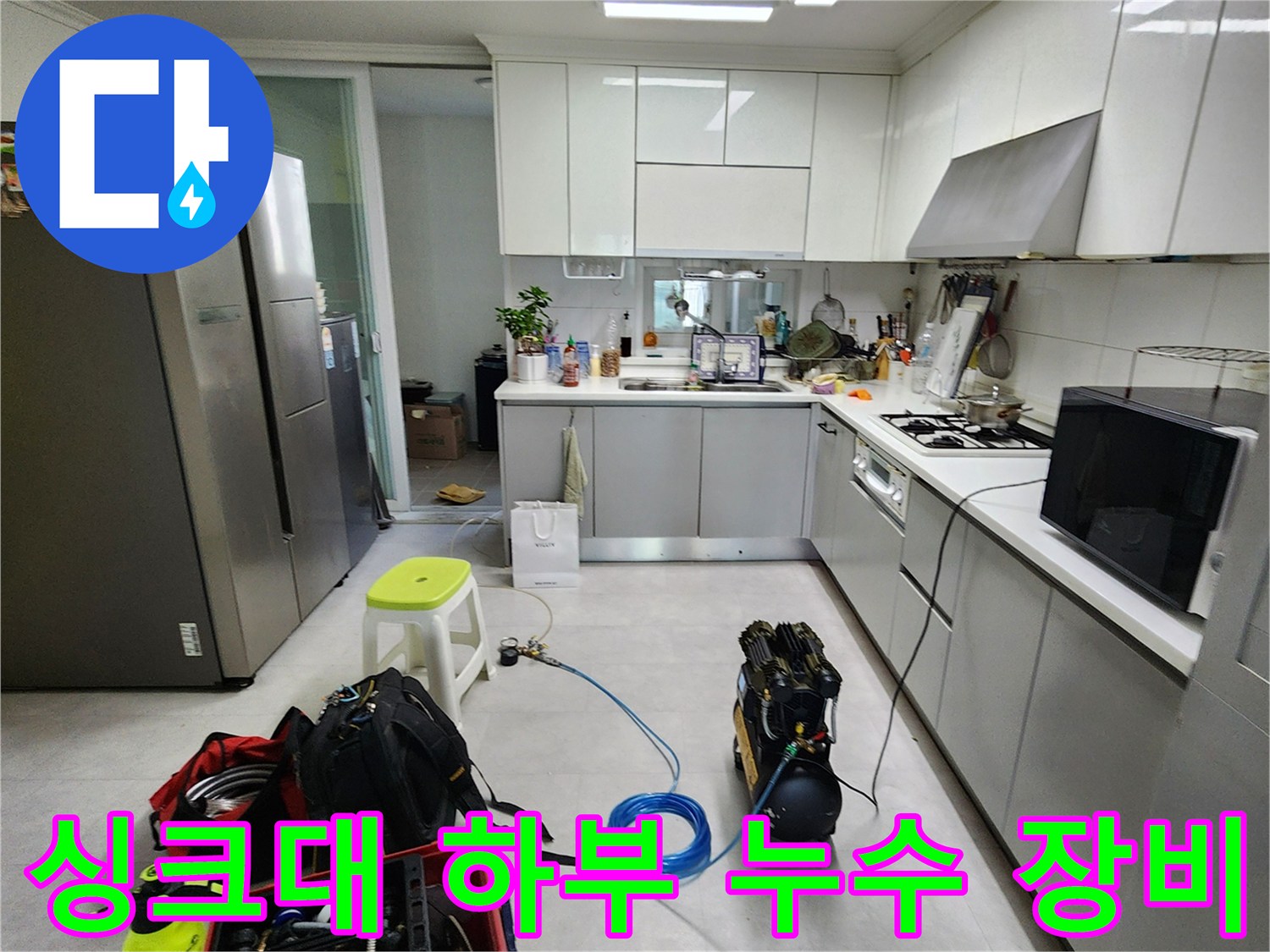 주방 싱크대 밑-배수관 상태를 확인하기 위해-배치된 각종 수리 도구와 자재