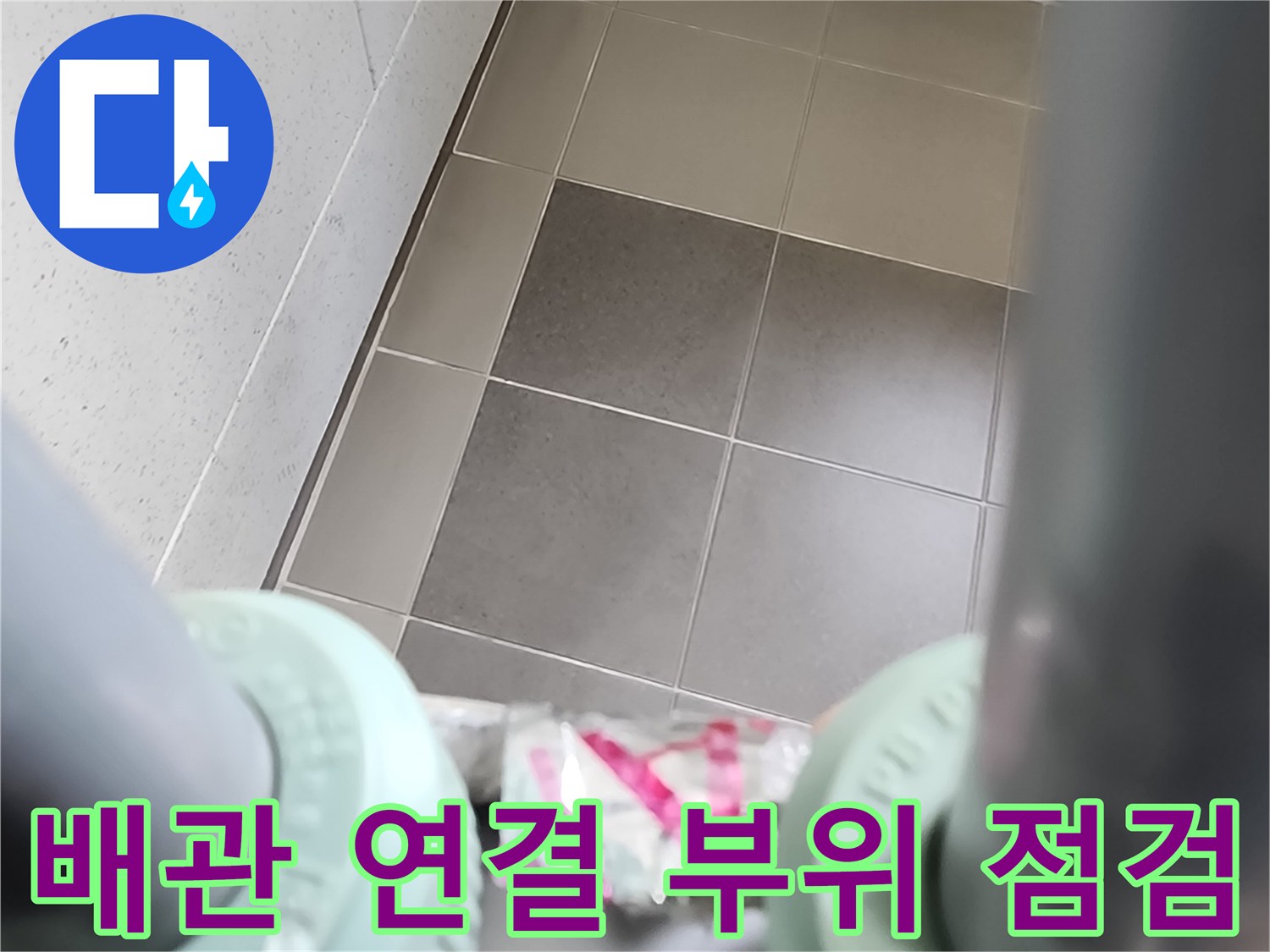 배관 엘보 부속과 타일 벽면의 접합부 근접 촬영