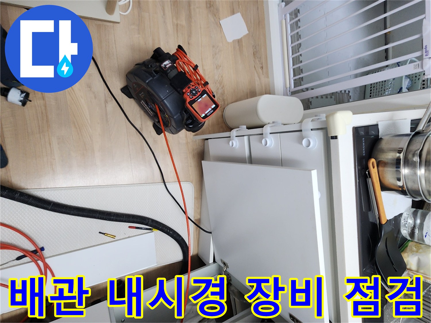 싱크대 하부장에서 배관 상태를 확인하기 위해 내시경 카메라 장비를 배치한 모습입니다.