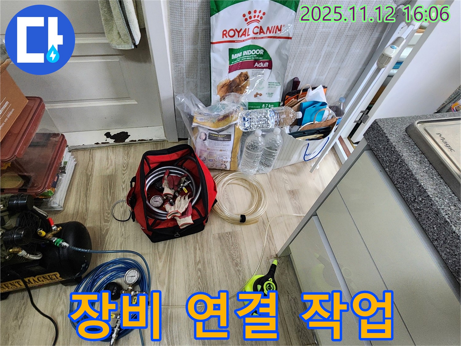 누수 탐지를 위한 장비 연결 작업 중 - 콤프레샤와 압력 게이지를 연결하여 압력 테스트를 준비합니다.