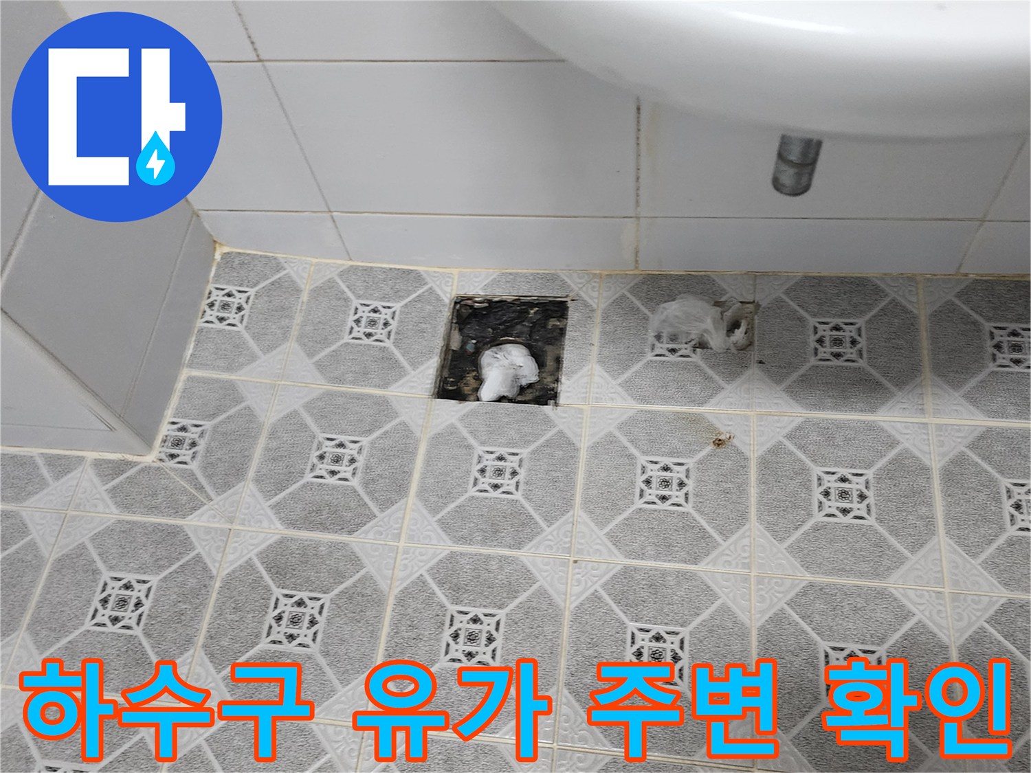 욕실 배수구 입구와 타일 사이의 습기 상태를 촬영한 사진입니다.