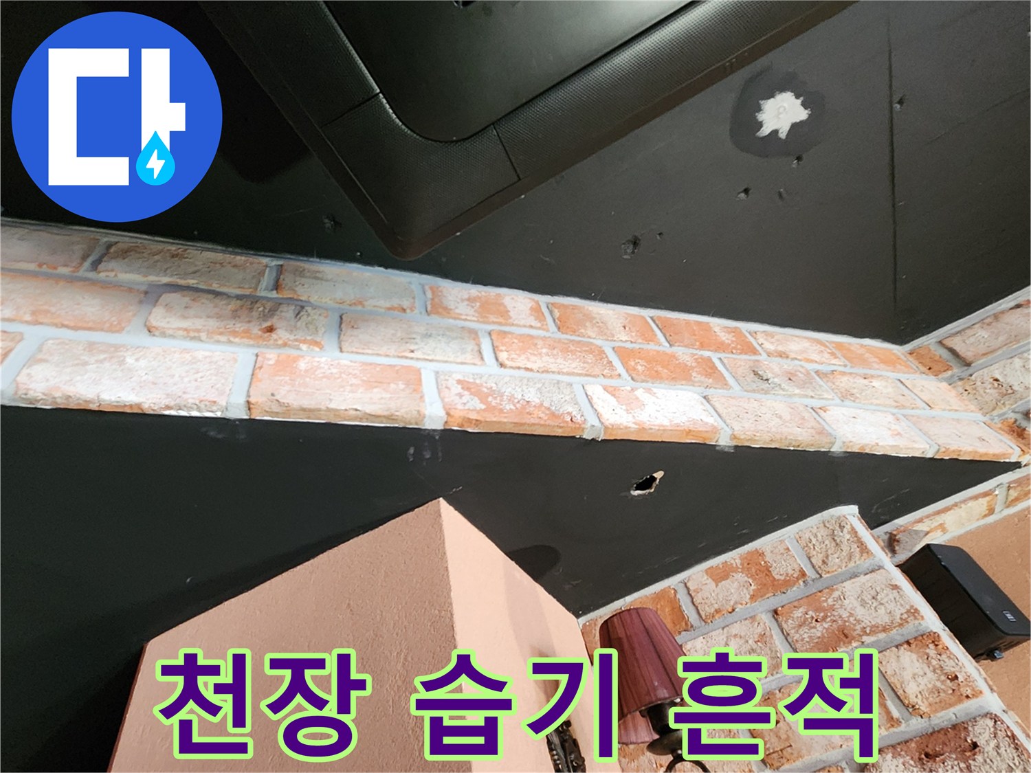 검은색 천장 패널 위로 나타난 하얀색 수분 침투 얼룩 부위
