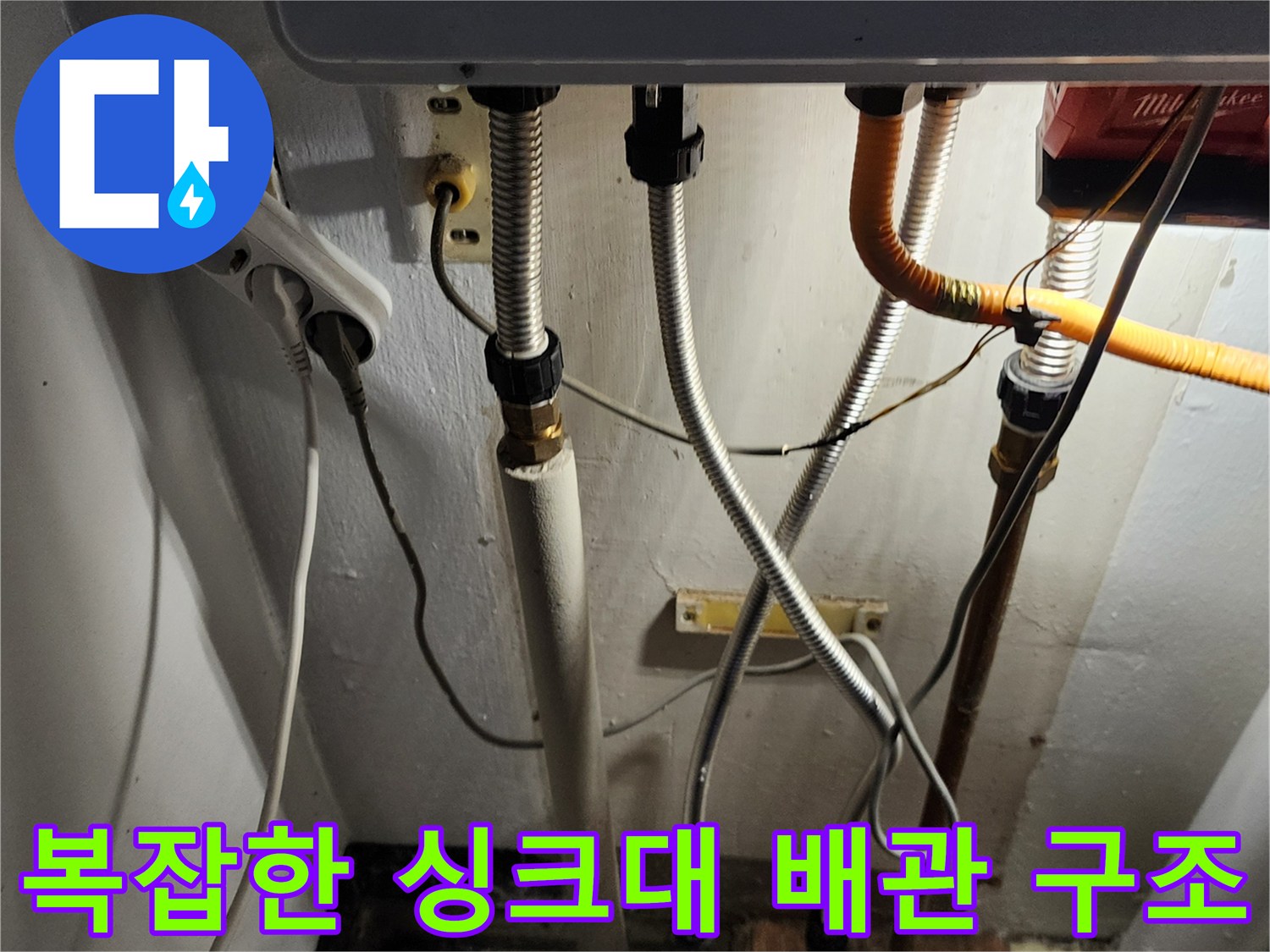 싱크대 하단에 설치된 다양한 규격의 배수 호스와 연결관들