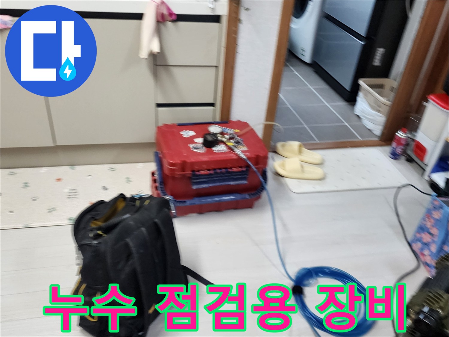 주방 바닥에 배치된 빨간색 공압 테스트 케이스와 파란색 에어 호스