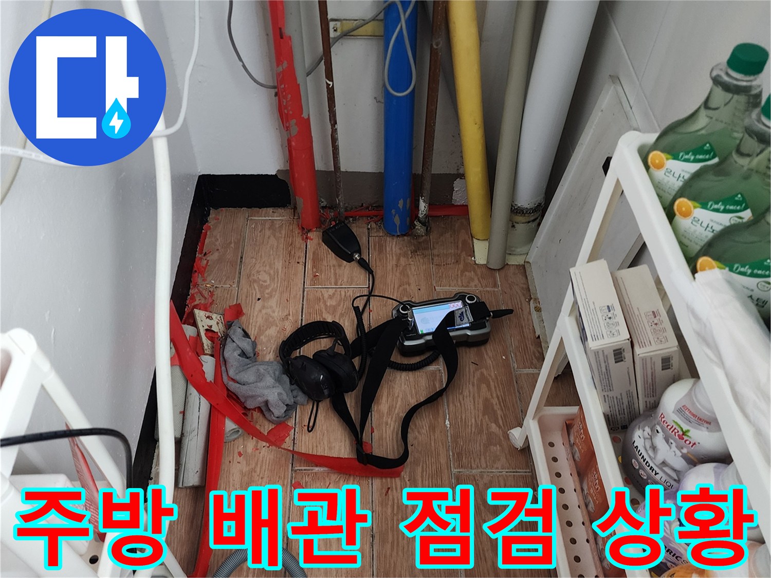 주방 하부장 내부의 다양한 배관과 탐지 장비 모습