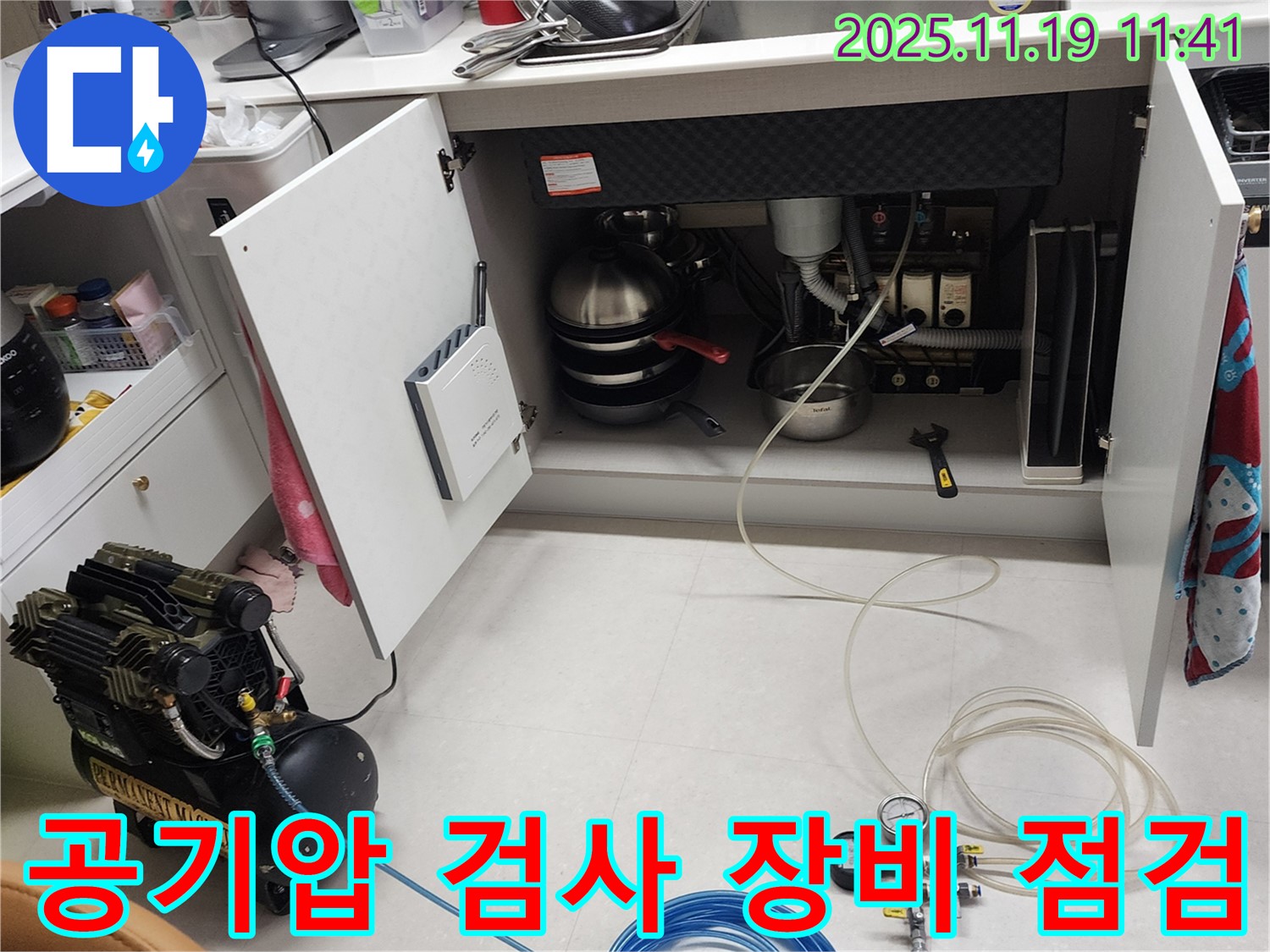 포천 내촌면 마명리 누수 현장 - 싱크대 하부에서 공기압 검사를 위해 사용되는 장비들을 꼼꼼하게 점검하는 모습입니다.