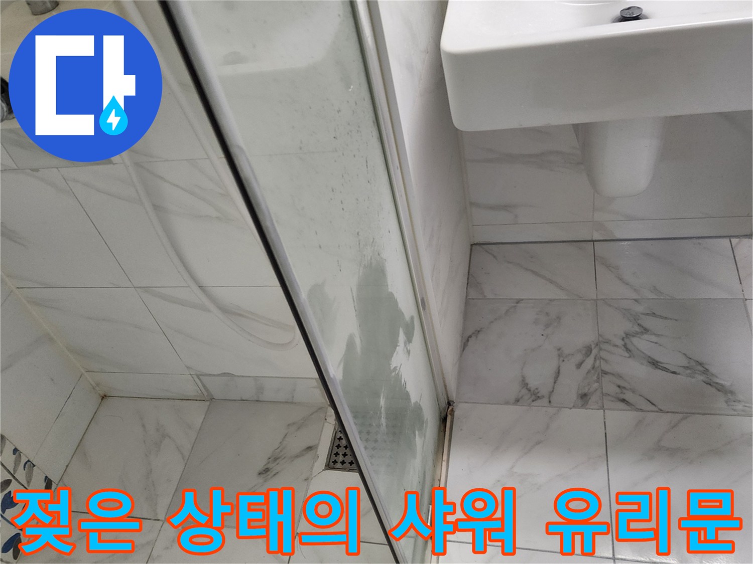 샤워부스-유리창에-맺힌-물기와-세면대-하단-타일