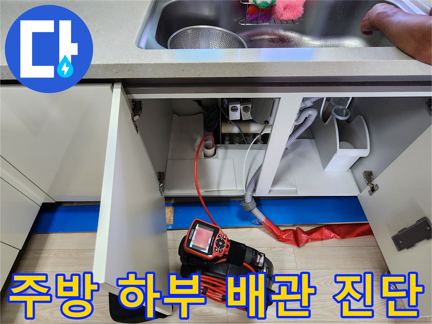 싱크대 밑 배관에 연결된 붉은색 공압 테스트 호스