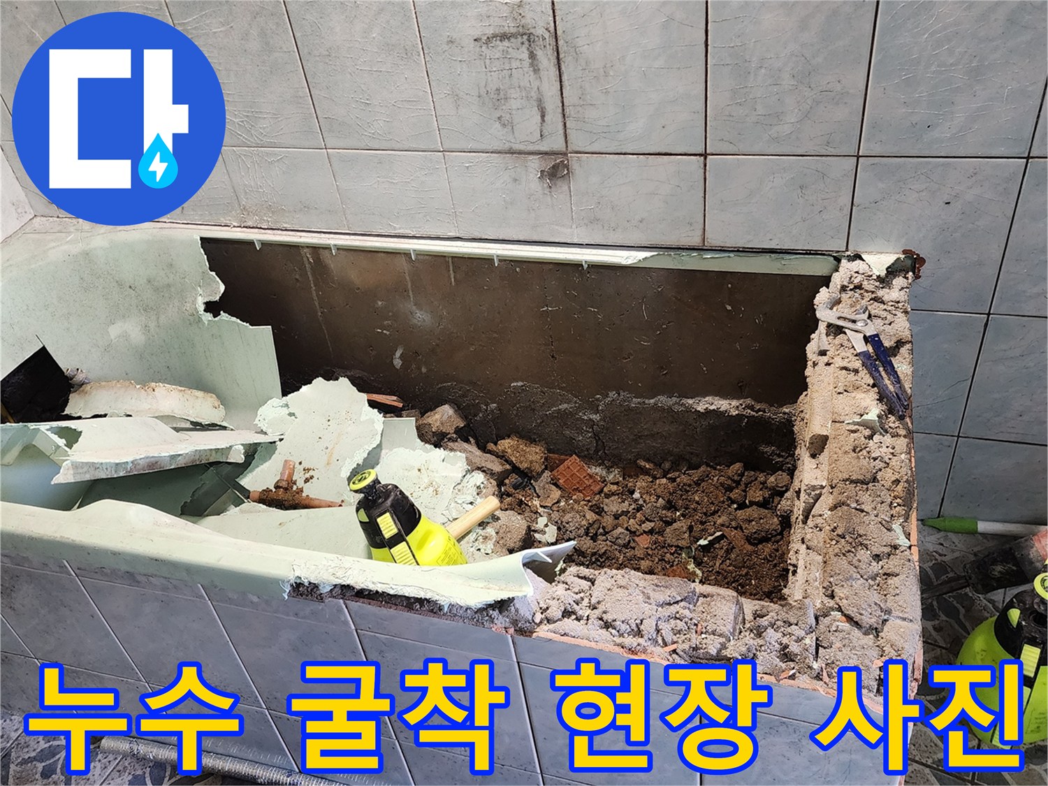 타일이 제거된 자리의 젖은 토사와 배관 주변 모습입니다.