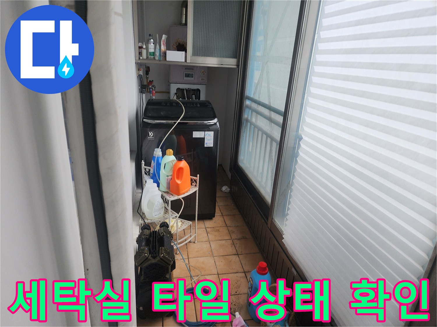 세탁기 주변 타일과 세제통이 놓인 세탁실 내부 전경
