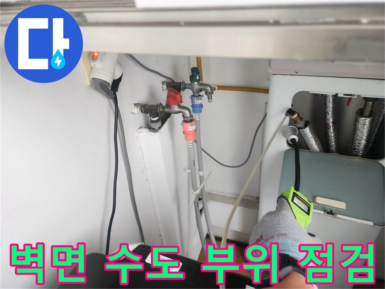 세탁실 벽면에 설치된 수전과 배관 연결부를 정밀하게 진찰하는 모습