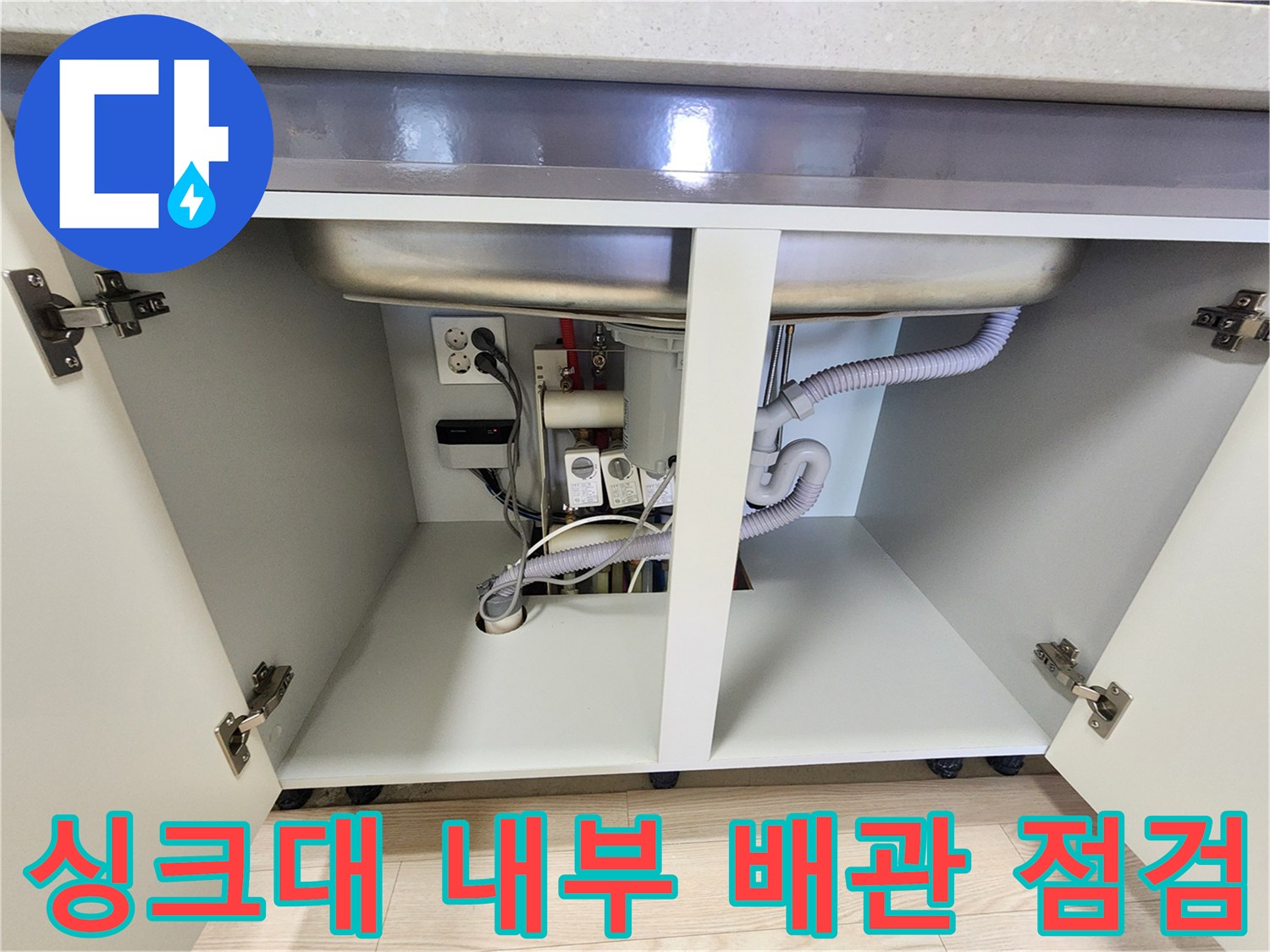 주방 싱크대 하부의 굴곡진 배수 호스와 연결된 부위 상세 사진