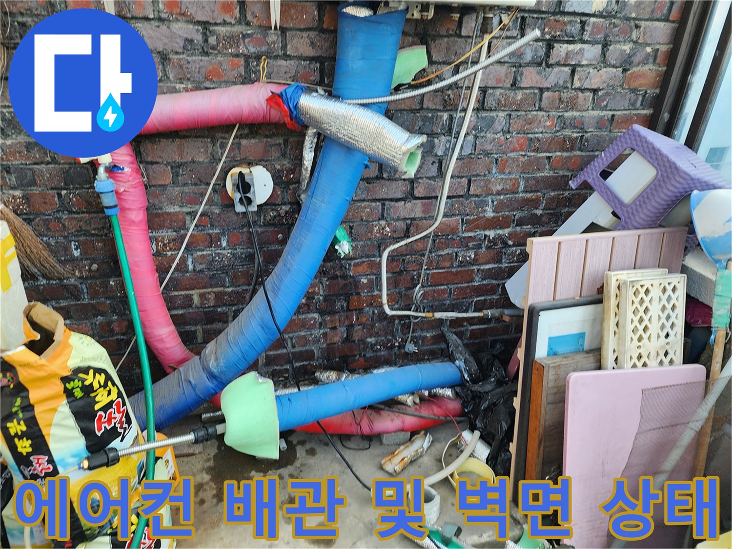 벽돌 외벽을 지나는 에어컨 배관의 단열재와 연결 부위 상세 모습