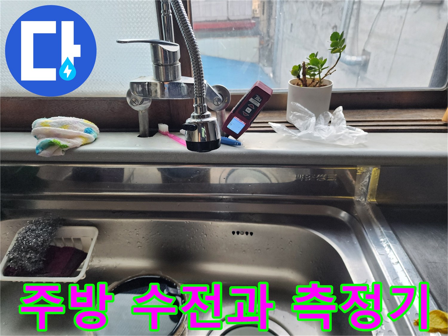 싱크대 수전 옆에 놓인 디지털 온도계와 청소용품