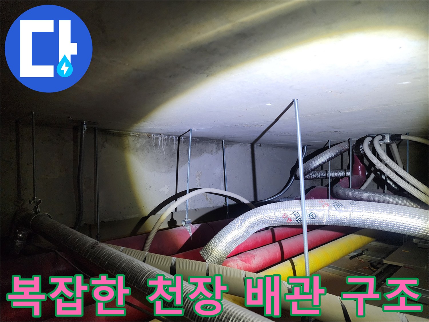 다양한 색상의 배관과 은박 보온재가 섞인 천장 내부 모습