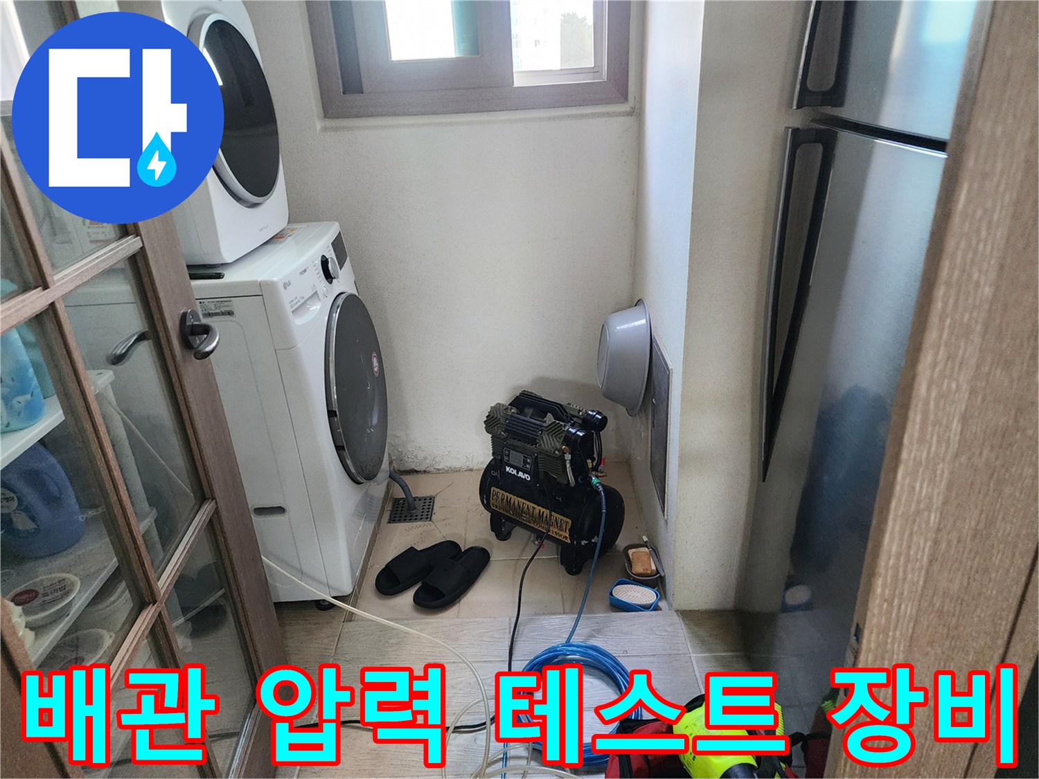 세탁실 구석에서 진행 중인 배관 압력 측정용 컴프레셔 작업 모습