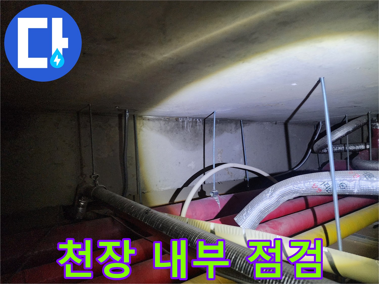 어두운 천장 공간 속 배관들의 연결 상태를 정밀하게 관찰합니다.