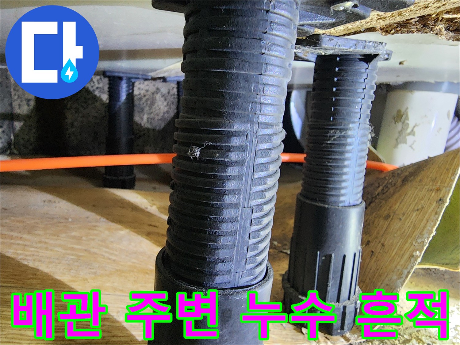주황색 배관과 검은색 지지대 주변의 습한 상태를 보여주는 사진