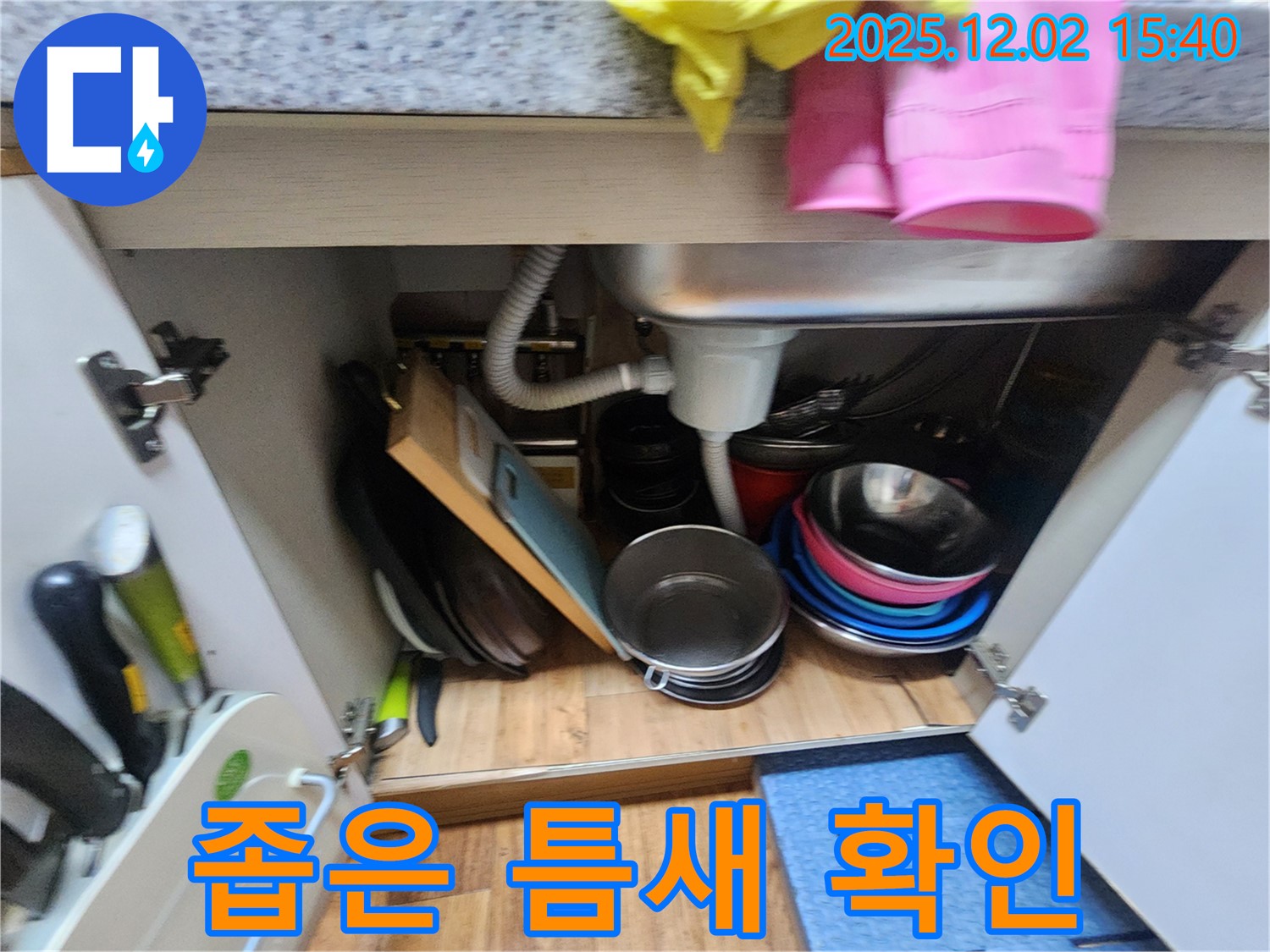 일동에서 싱크대 하부 공간의 좁은 틈새까지 꼼꼼하게 확인하고 있습니다 - 작은 틈새도 놓치지 않고 누수 여부를 확인합니다.