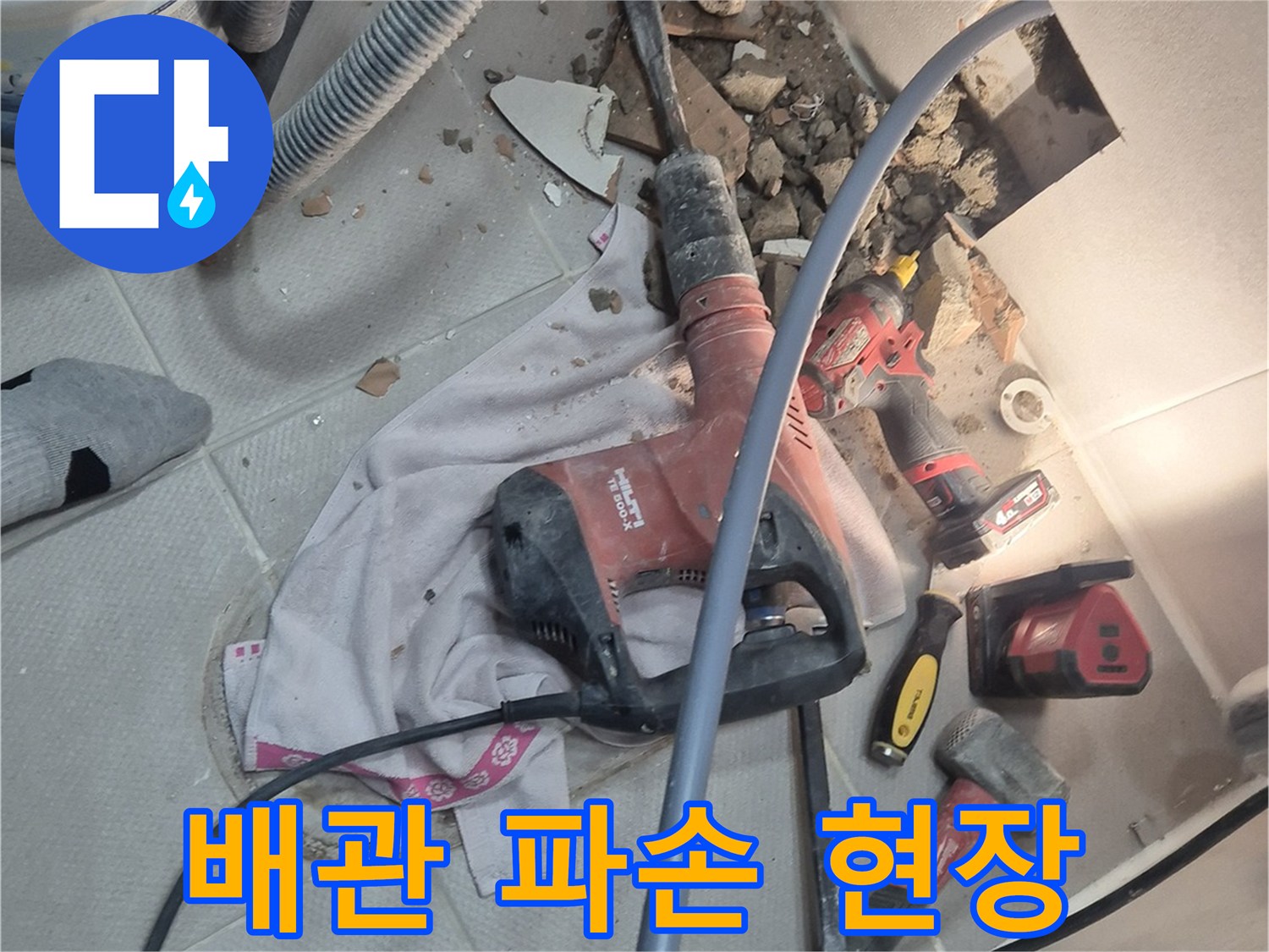 지행동 동양엔파트 아파트 누수 현장 - 망치질로 배관 파손 부위를 확인하는 이미지입니다.