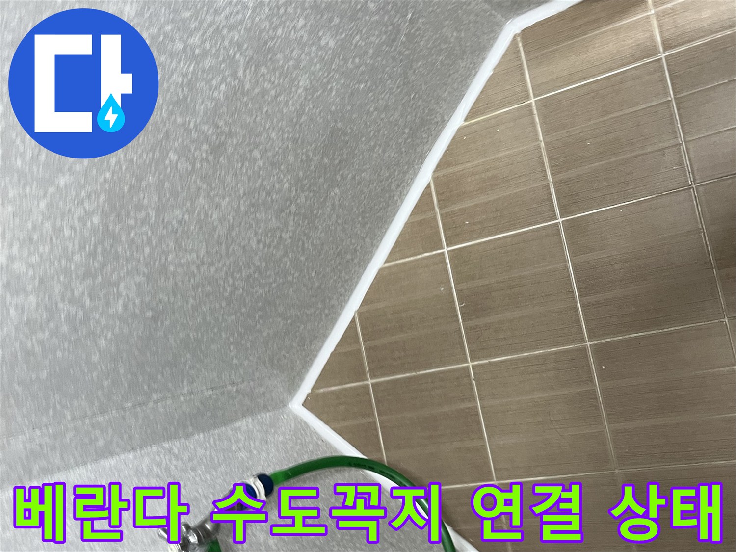벽면에 고정된 수전과 초록색 호스 연결 부위 근접 촬영