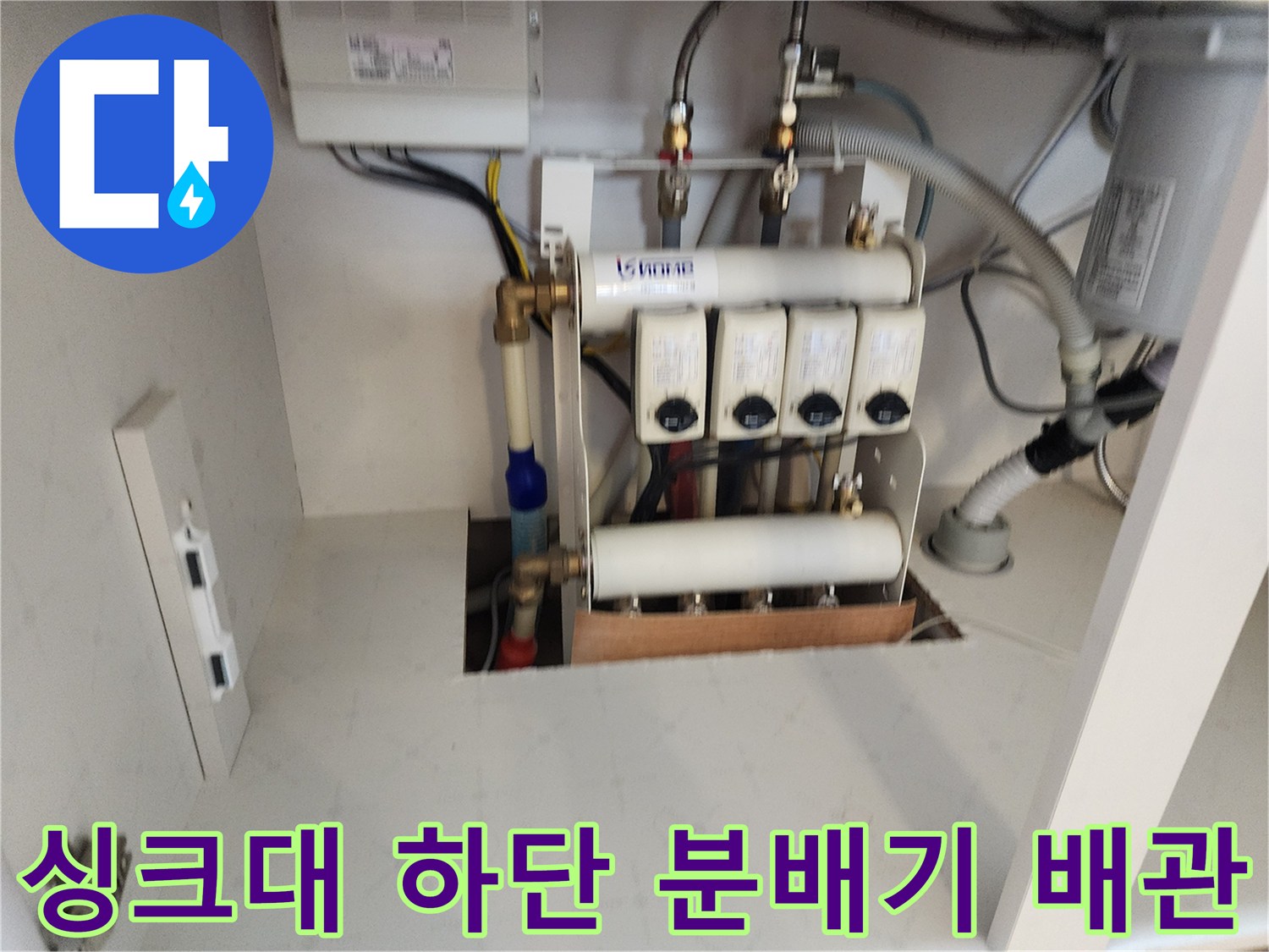 싱크대 밑 공간에 설치된 급수 분배기와 연결 부위들