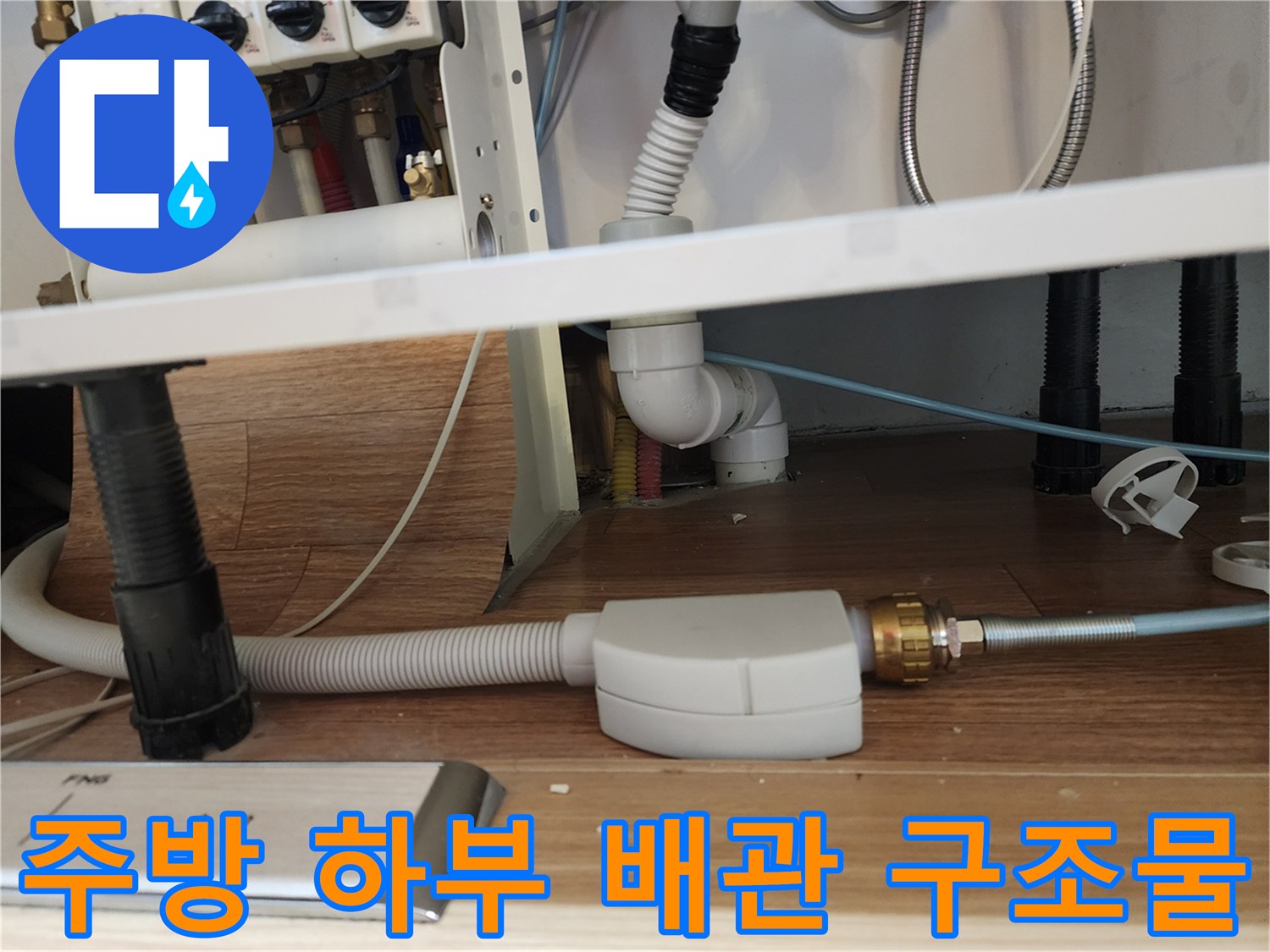 싱크대 아래 복잡하게 연결된 급수 및 배수 라인 확인