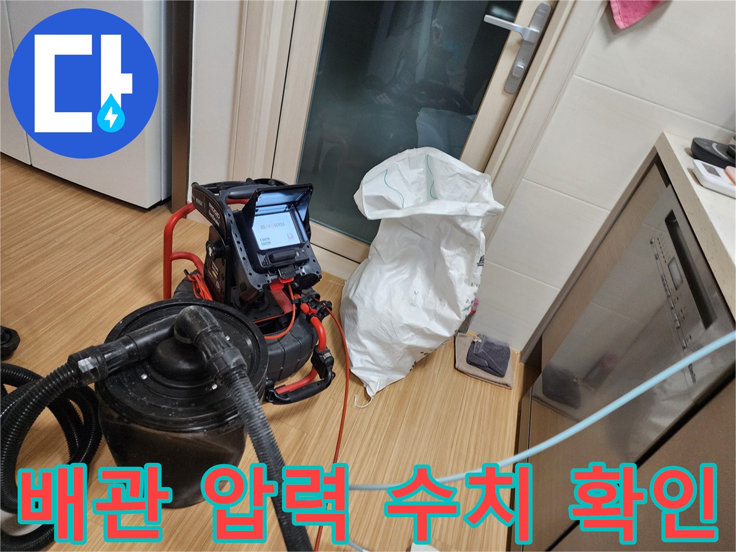 싱크대 하단 배관의 공압 테스트 진행 중인 장비와 게이지