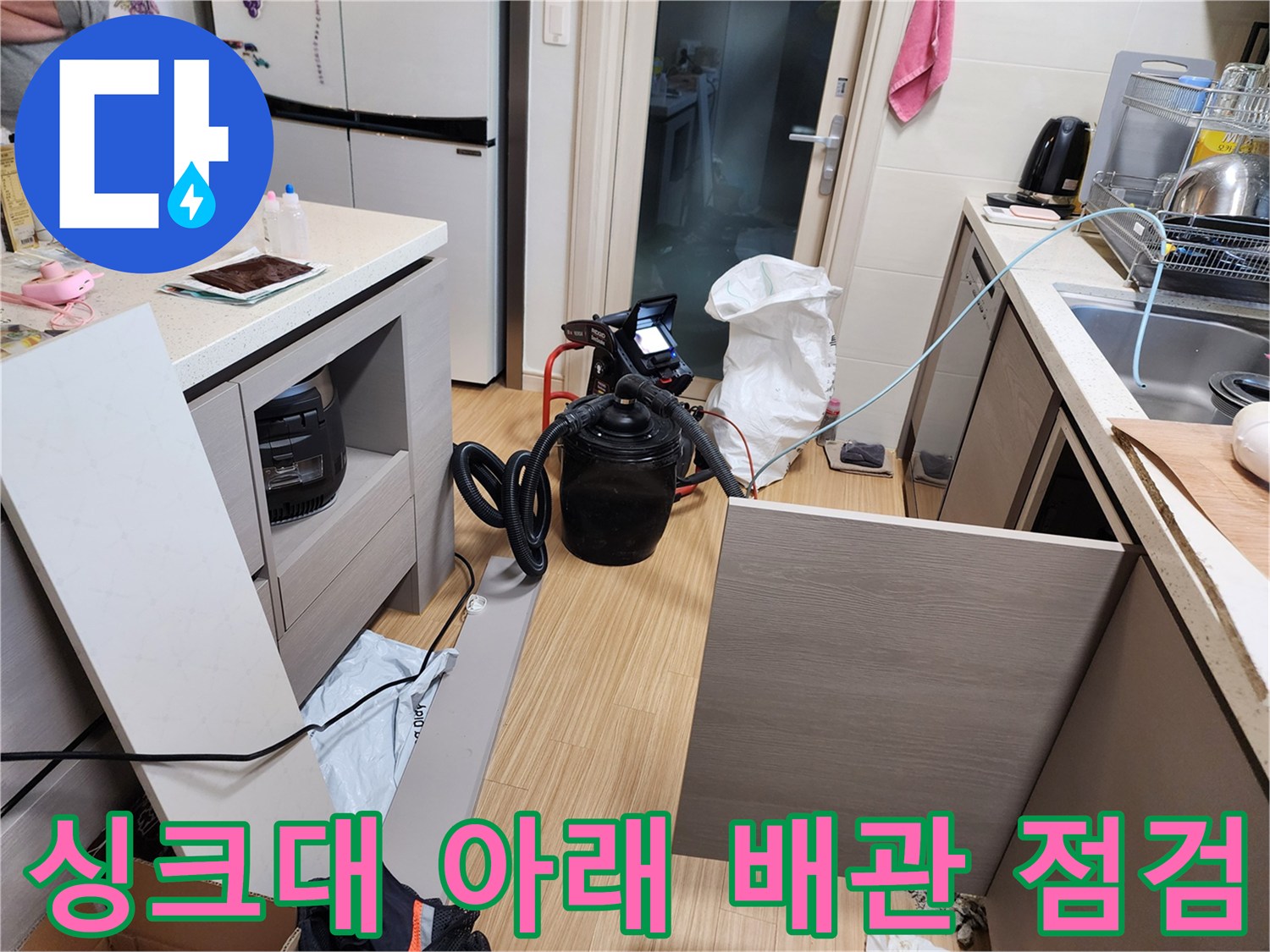 싱크대 하부 공간에 연결된 압력 측정용 장비와 호스 연결 모습입니다.