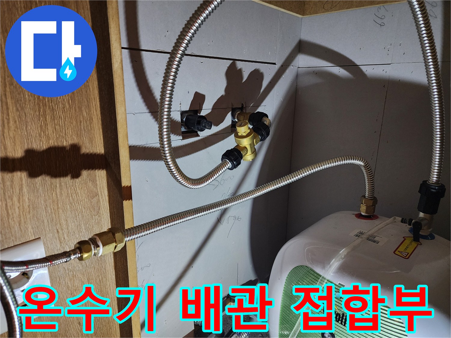 전기 온수기와 은색 금속 호스가 연결된 상세 사진
