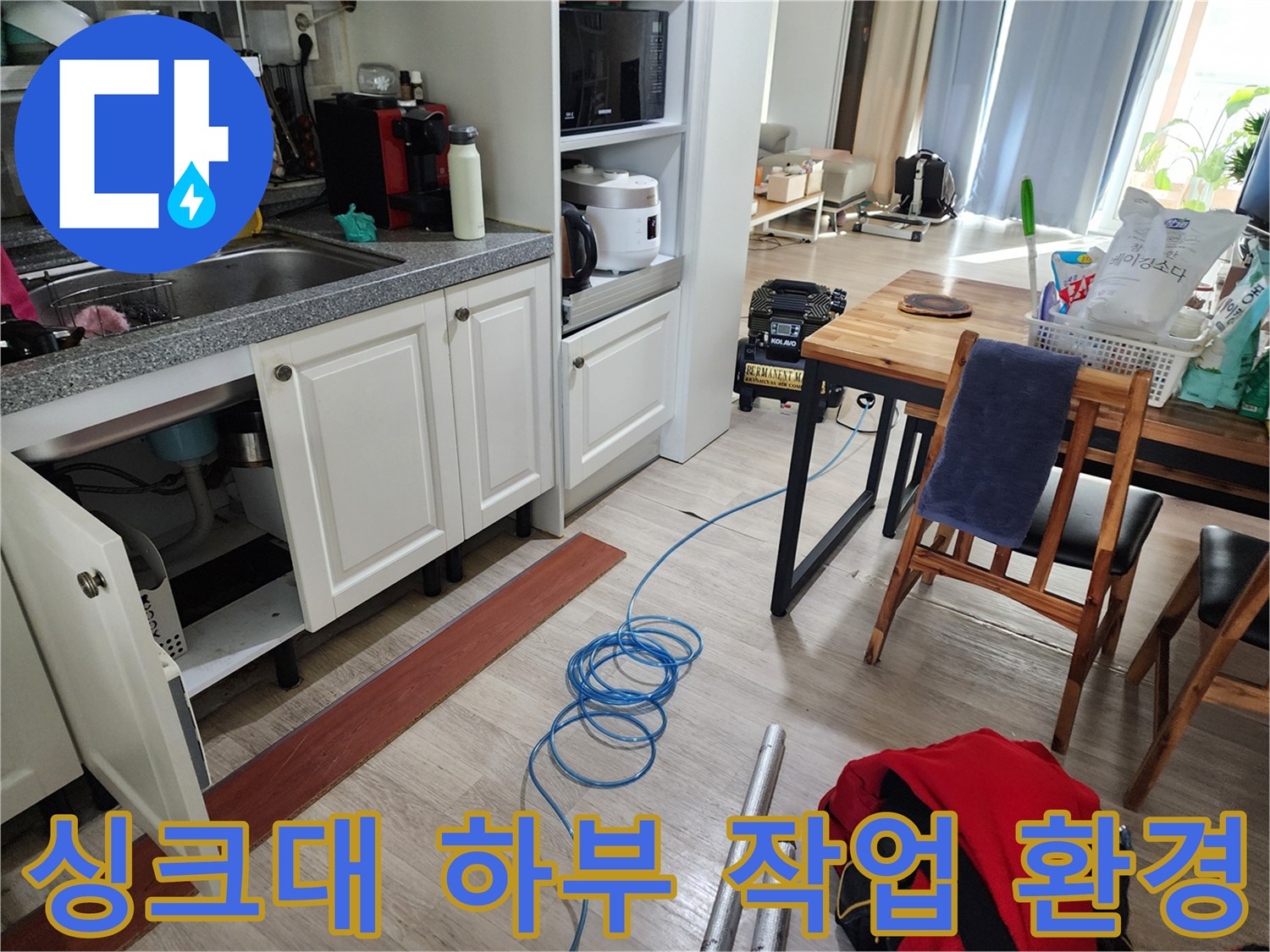 싱크대 아래 공간에 놓인 탐지용 호스와 주변의 목재 의자