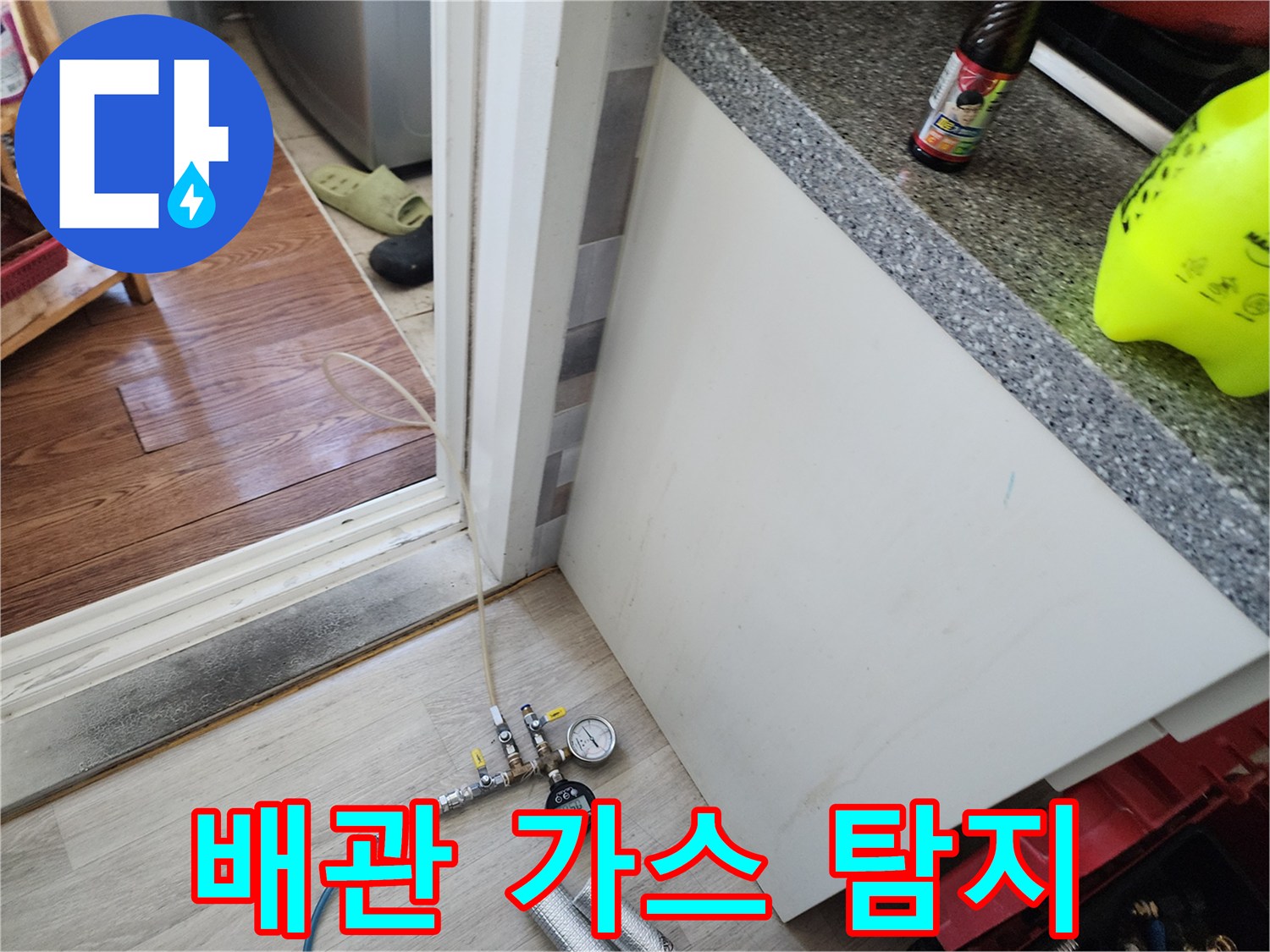 압력 게이지와 배관 연결 부속에 연결된 파란색 테스트 호스