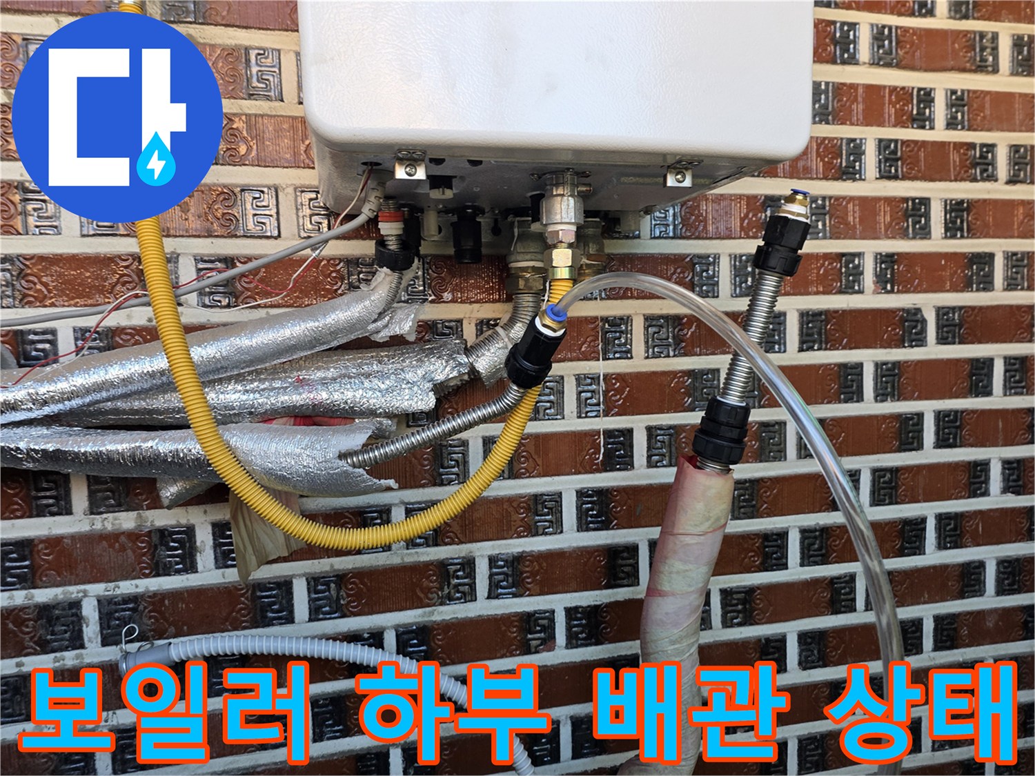 벽돌 벽면에 설치된 보일러와 연결된 다양한 배관들의 복잡한 구조-현장 기록
