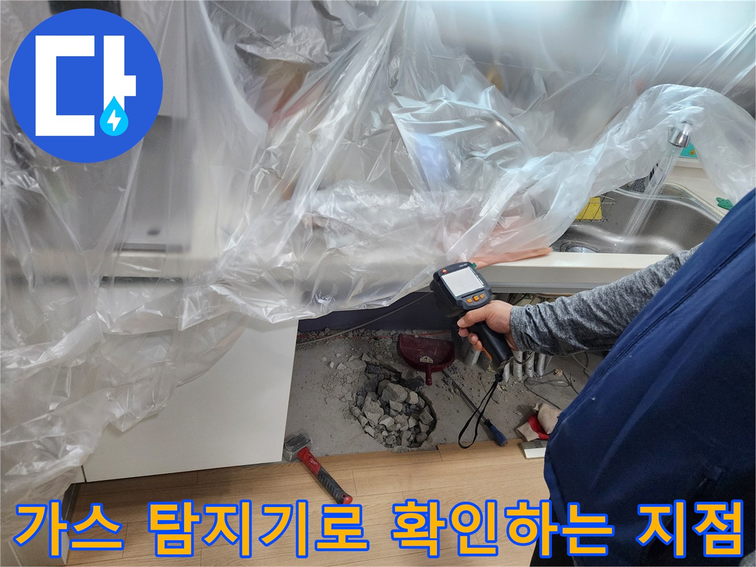 싱크대 밑 배관 누수를 찾기 위해 가스 탐지기를 사용하는 현장