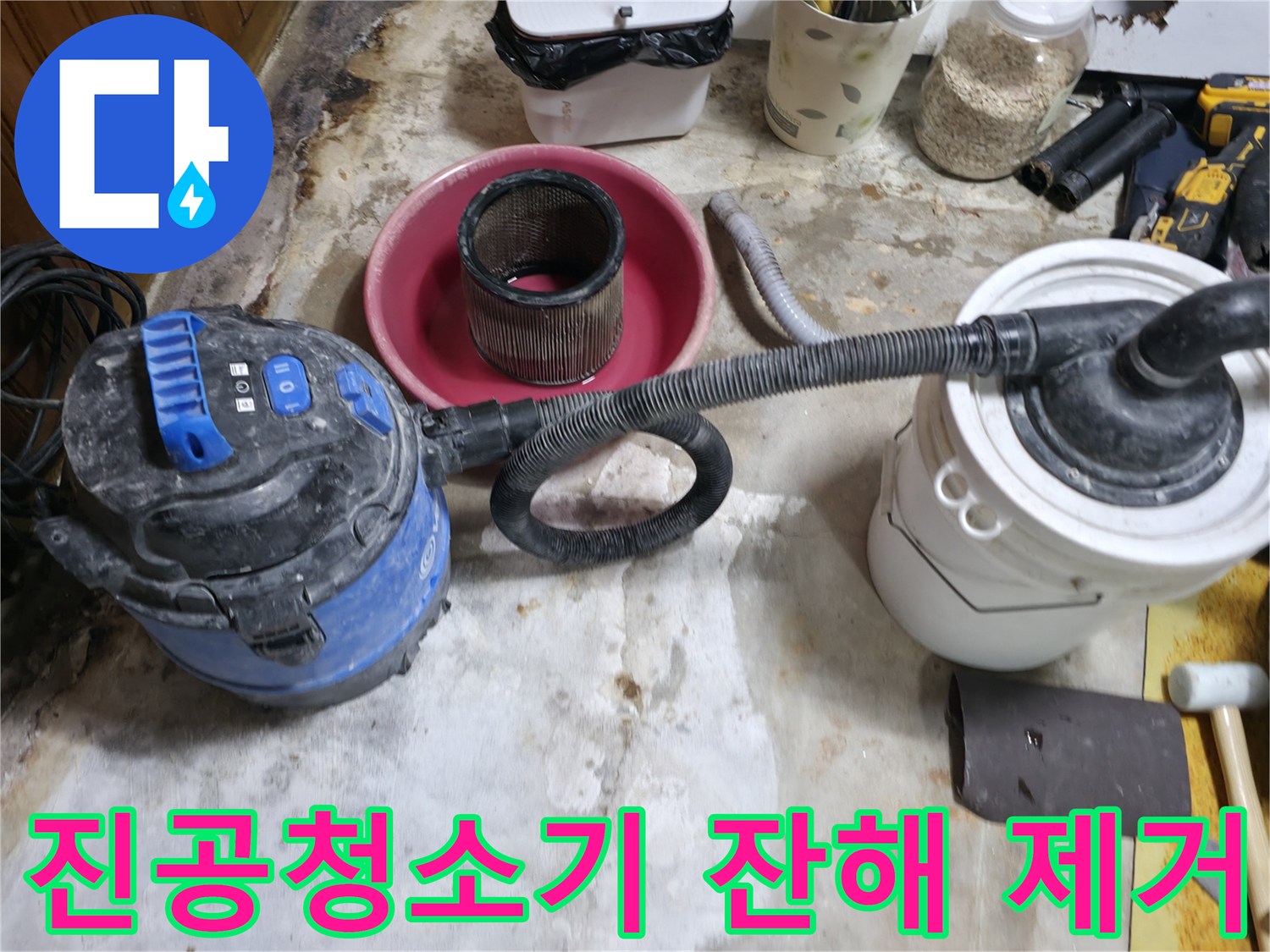 배관 보수 작업 - 청소기를 사용하여 굴착 부위의 먼지를 흡입함