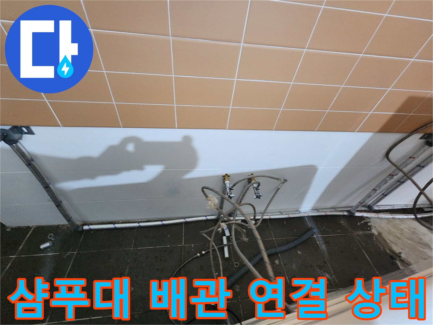 미용실 샴패대 하단 배관 연결 부위와 벽면 타일 모습