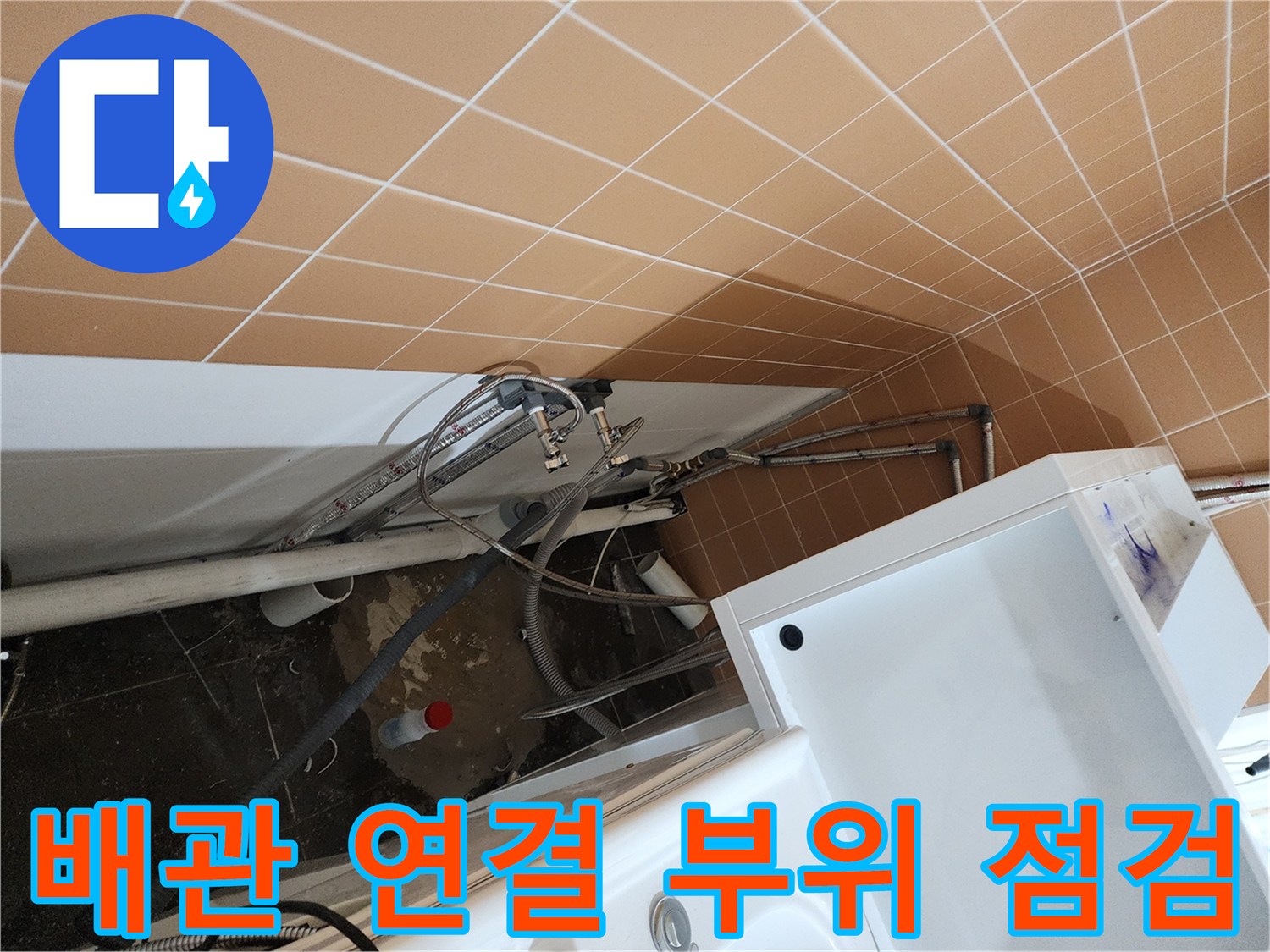 샴푸대 아래 복잡하게 얽힌 배관과 벽면 타일 접촉 부위입니다.