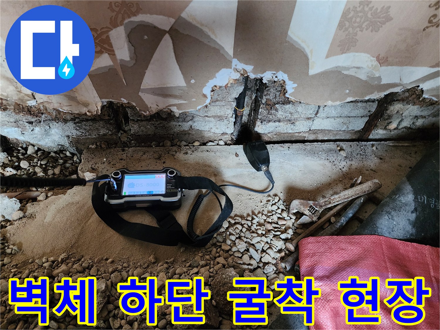 벽면 하단부 벽지를 제거하고 드러난 배관 주변의 누수 탐색 모습입니다.